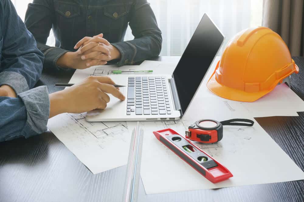 Depositphotos_268265150_S (1) Tech-savvy Wellington based Smartway Builders team using a laptop to plan and manage a construction project.