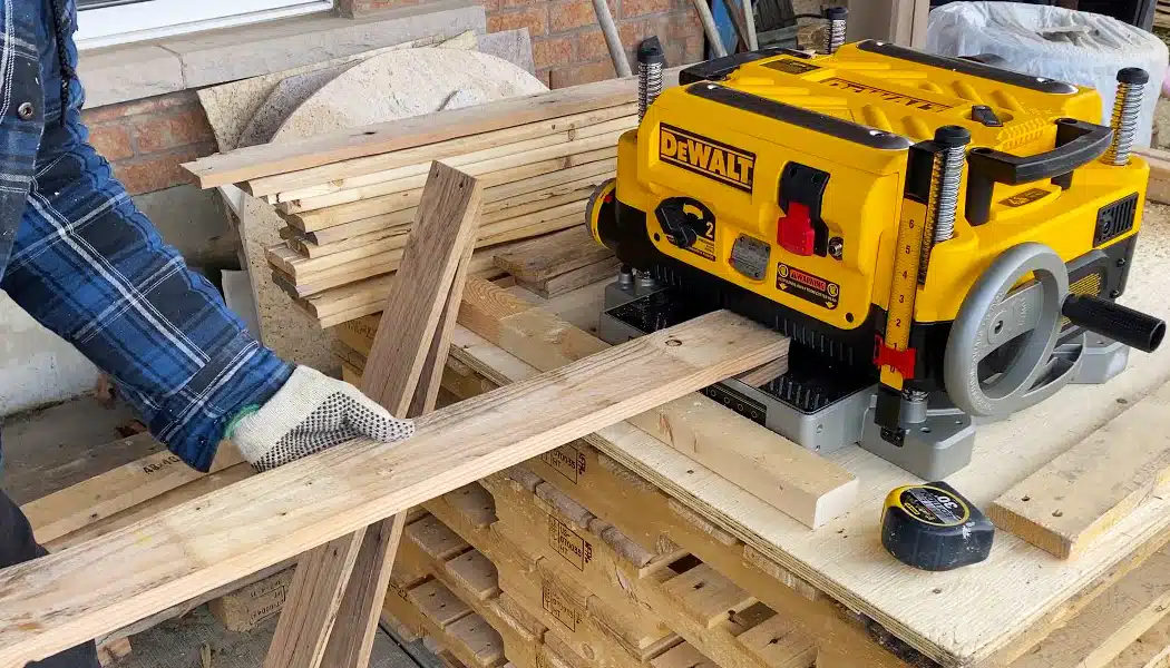 Cutting_Wood Worker feeding planks into a finishing machine